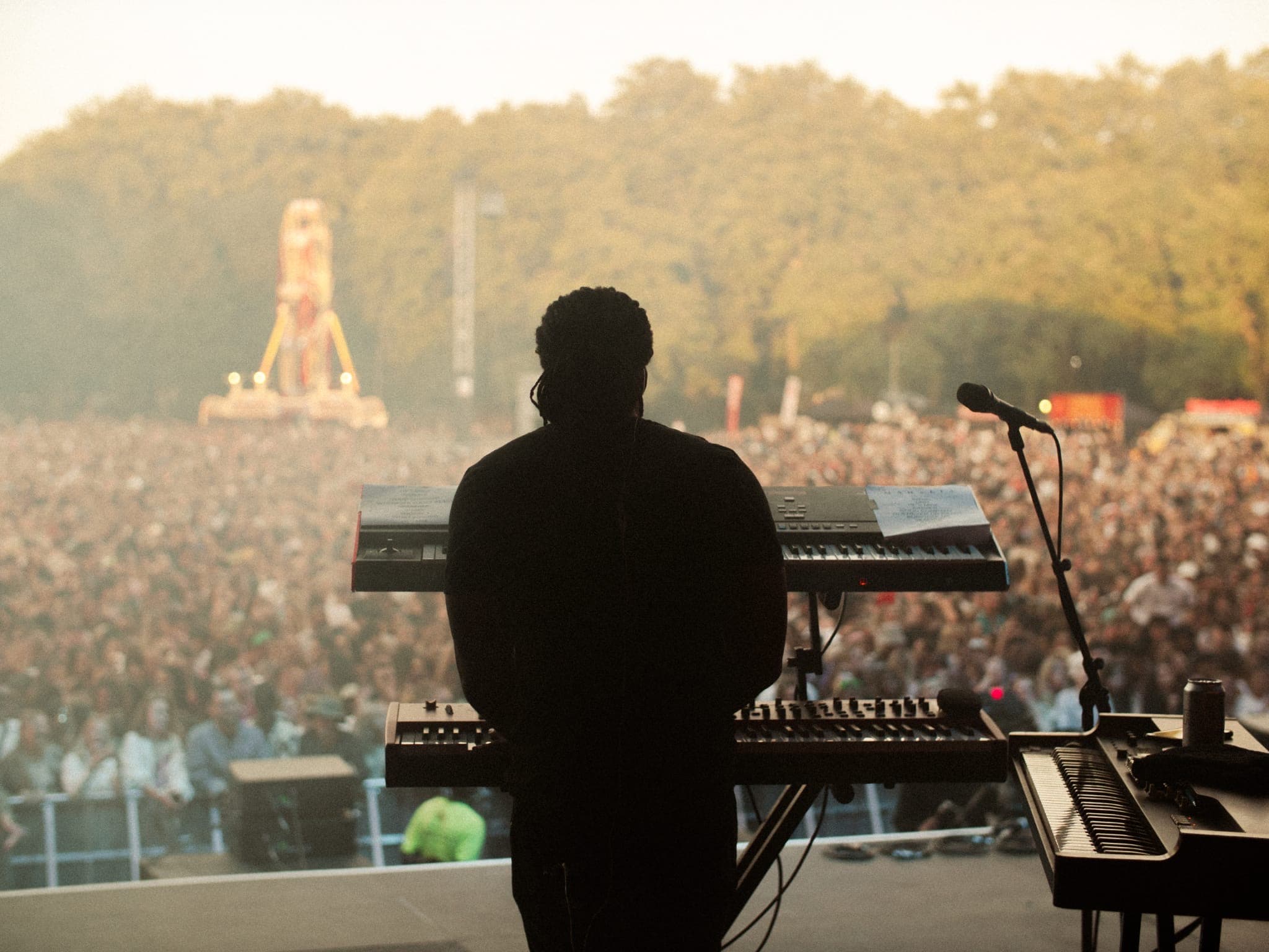 Behind the keys on a festival stage, looking out over the crowd